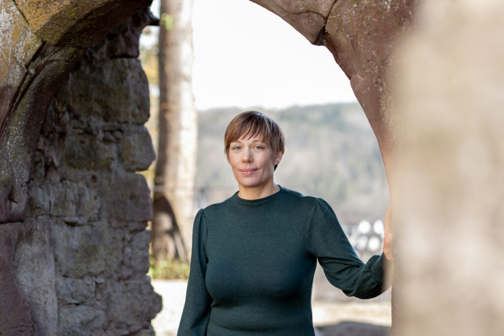 Dorothee Hildbrand steht ruhig an einer Mauer und bietet achtsame Coaching-Begleitung