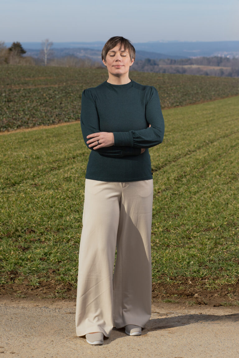 Dorothee Hildebrand steht ruhig und fokussiert in der Natur – symbolisch für den Moment, in dem Worte nicht mehr ausreichen und innere Veränderung beginnt.
