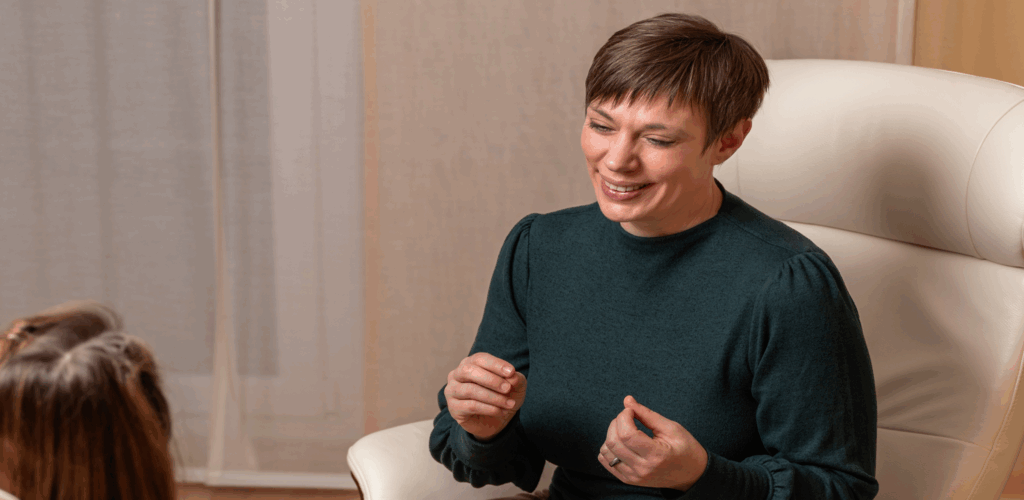 Dorothee Hildbrand lacht zugewandt im Coaching-Gespräch mit einer Klientin während der ersten Sitzung